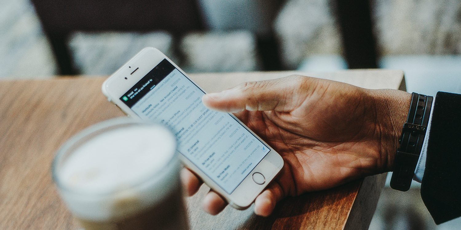 dicas-para-aprimorar-sua-campanha-de-e-mail Homem segurando iphone
